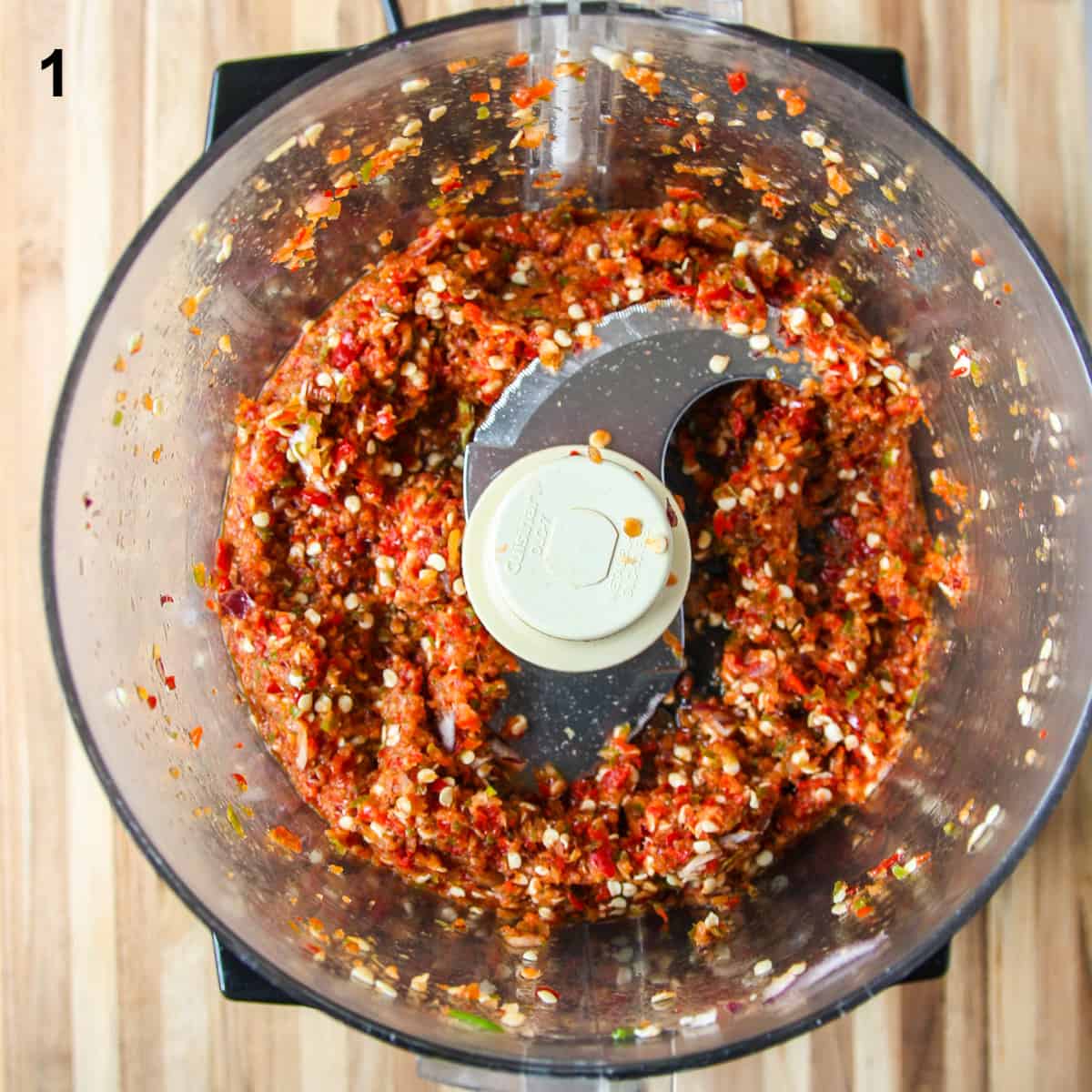 The finely chopped ingredients, except the vinegar, in the bowl of a food processor.